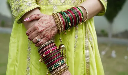 Hariyali Teej: a woman's hands with green bangles and mehndi