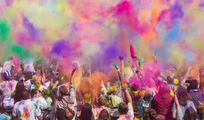 Holi: a crowd celebrating Holi in clouds of coloured gulal