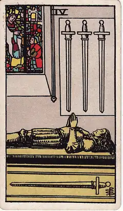Four of Swords. A knight lies in effigy on a tomb with hands in prayer, one sword beneath him and three hanging on the wall above.