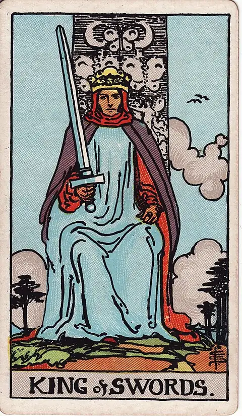 King of Swords. A crowned king sits square on his throne holding an upright sword slightly tilted, two butterflies carved behind him.