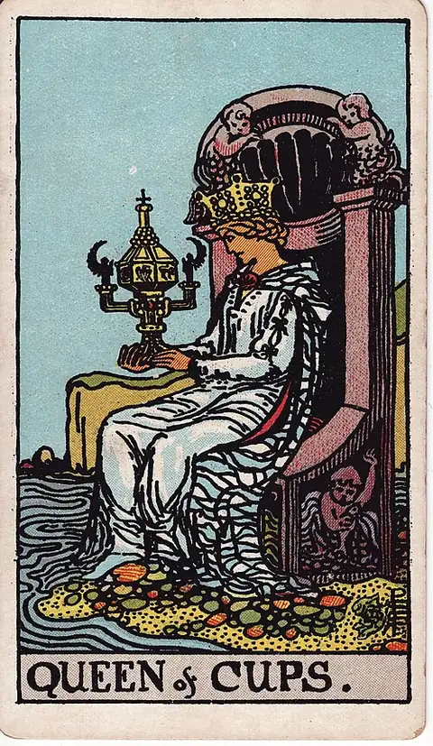 Queen of Cups. A crowned woman sits at the water's edge gazing into an ornate closed cup shaped like a shrine.