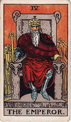 The Emperor. A bearded king sits square on a stone throne carved with rams' heads, holding an ankh sceptre, with bare red mountains behind him.
