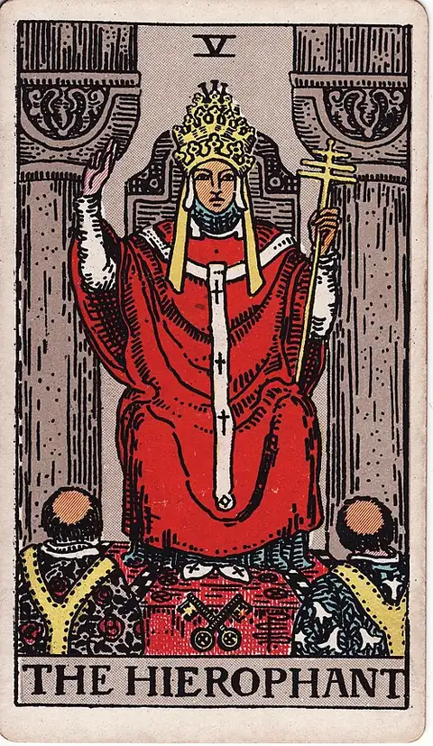 The Hierophant. A robed priest between two stone pillars raises a hand in blessing over two tonsured monks, with crossed keys on the floor.