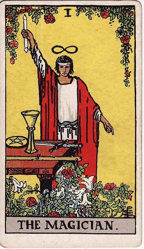 The Magician. A figure stands at a table of cup, coin, sword and wand, one arm raised to the sky and the other pointing to the ground, with a lemniscate above the head and roses and lilies below.