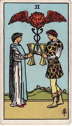 Two of Cups. A man and a woman face each other exchanging cups, a winged lion's head over a caduceus above them.